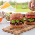 Two beet burgers with tomatoes, onion, lettuce and a soft bun.
