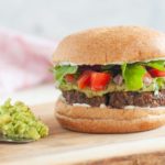 Lentil walnut burger with lettuce, tomato, and avocado.