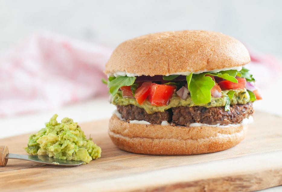 Lentil walnut burger with lettuce, tomato, and avocado.