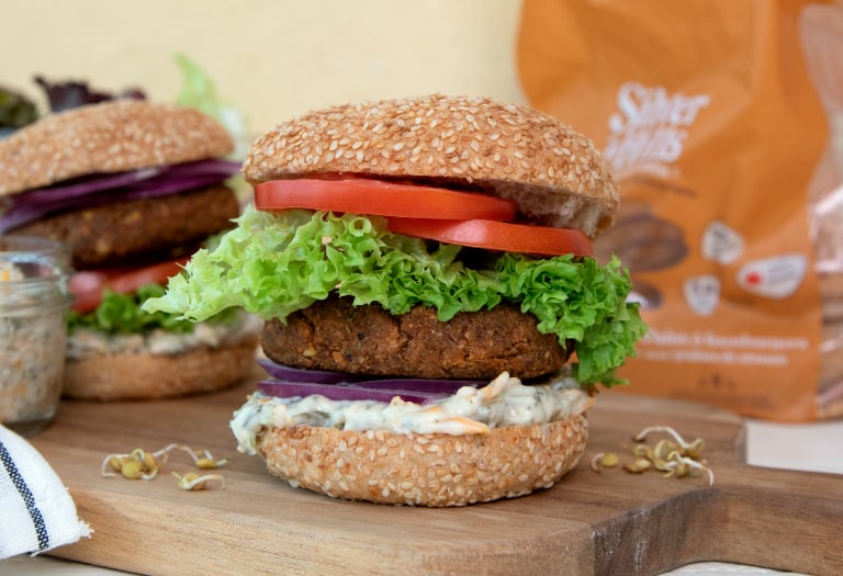 Sprouted Green Lentil Burgers with Vegan Pickle Dip burger sauce on a Silver Hills Bakery sprouted whole grain burger bun topped with  sesame seeds