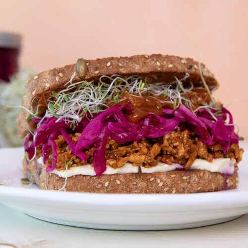 Sweet & Spicy BBQ Shredded Tofu Sandwich with Quick-Pickled Red Onions and Cabbage on a plate