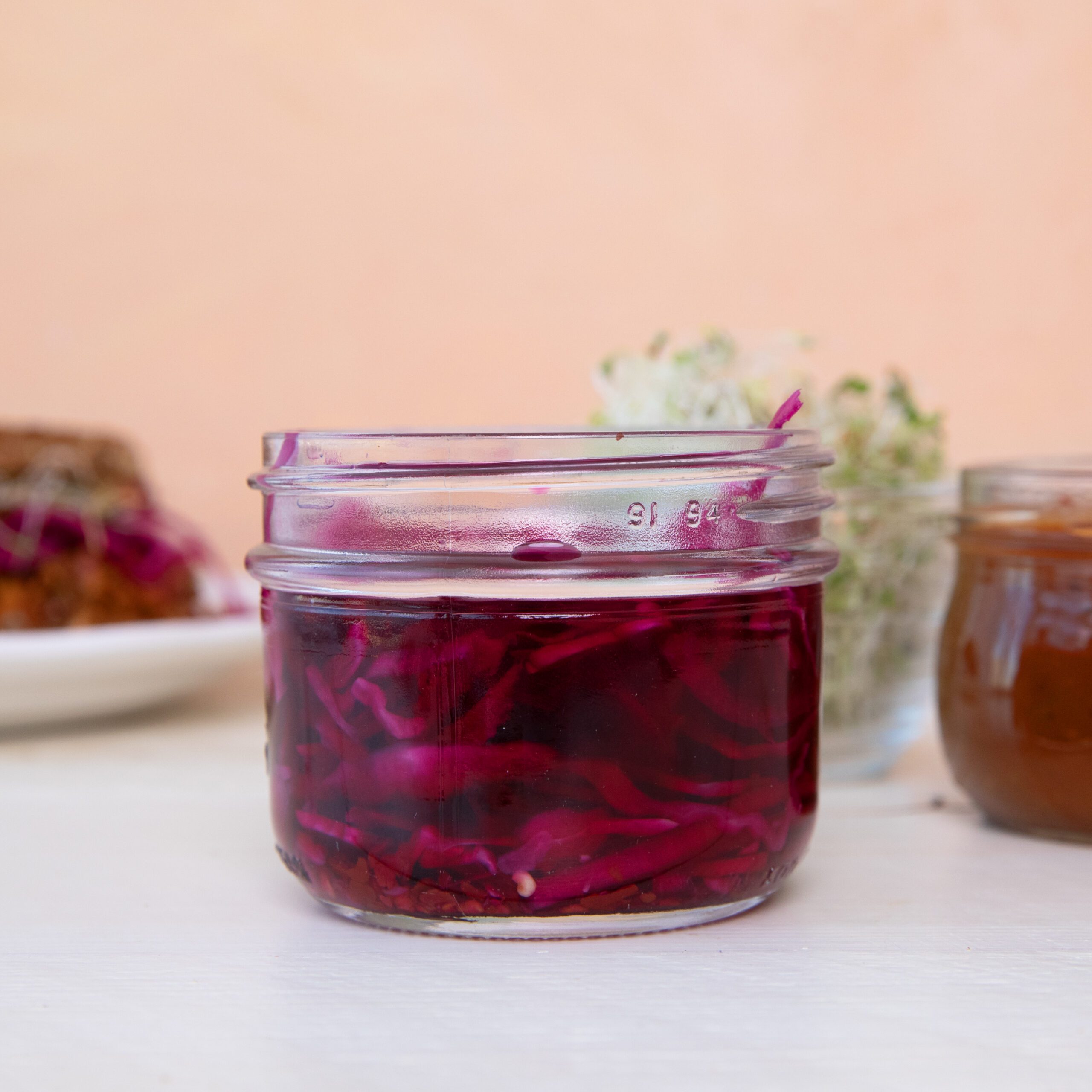 Close-up of Quick-Pickled Red Onions and Cabbage in a jar ready to top a sandwich