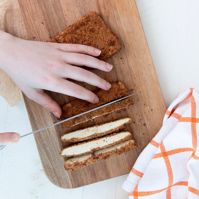 Crispy Air Fryer Tofu Katsu Sando with Sprouted Breadcrumb crust being sliced on a cutting board 